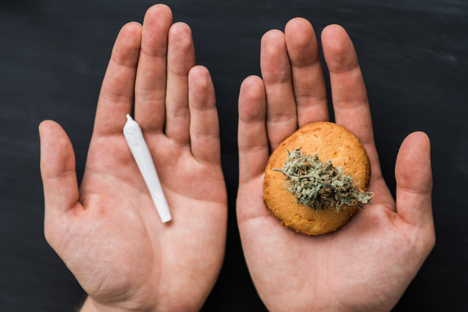 an image of two hands face up, one holding a marijuana joint and the other one holding an edible marijuana cookie